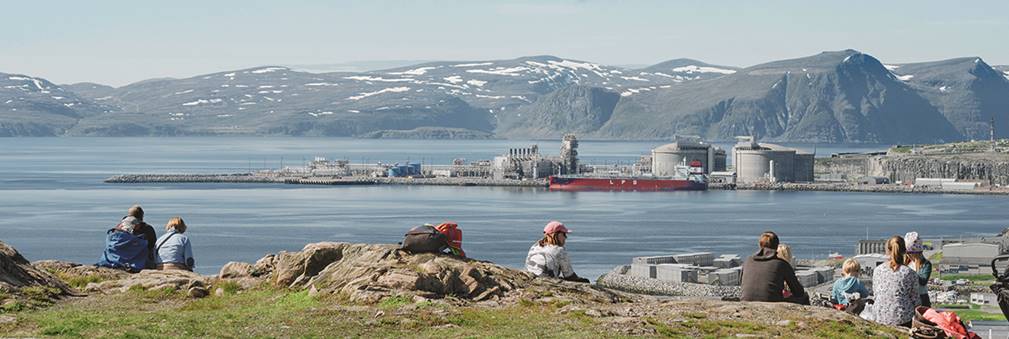 A group of people standing next to a body of water

Description automatically generated